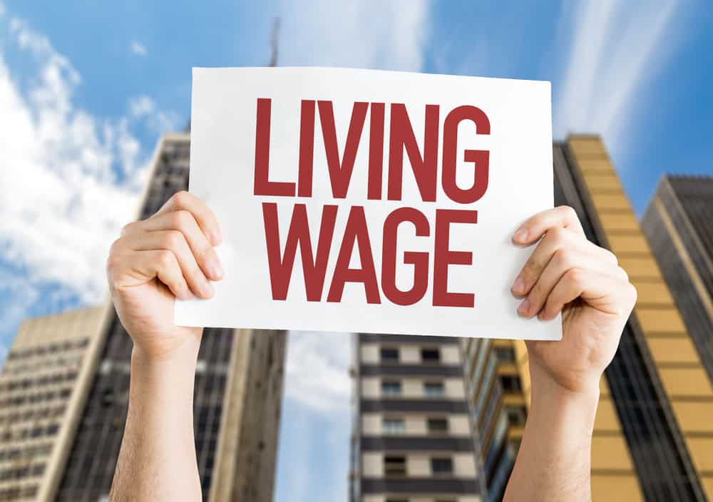 Person holding up a Living Wage banner