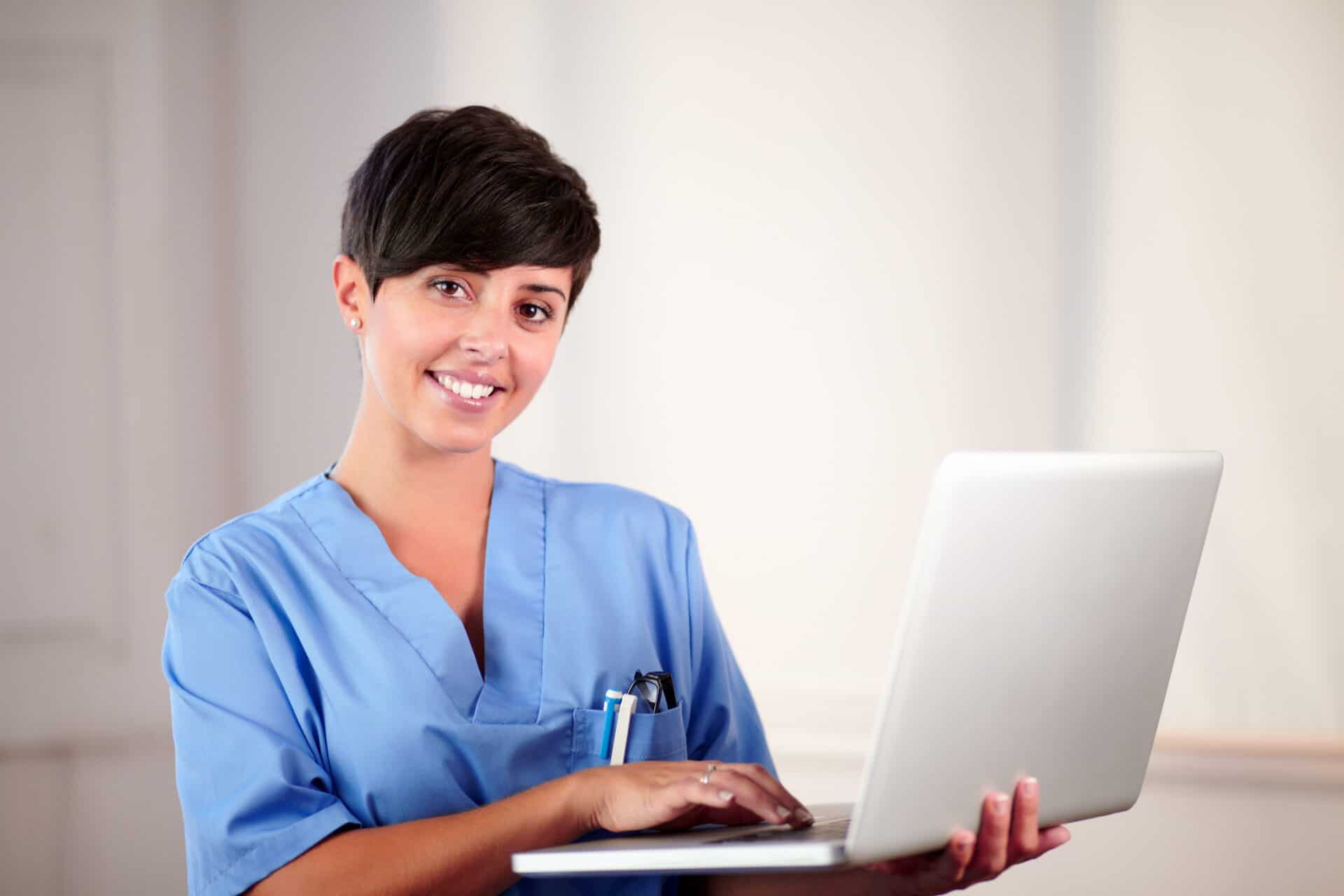 Dental professional working at laptop