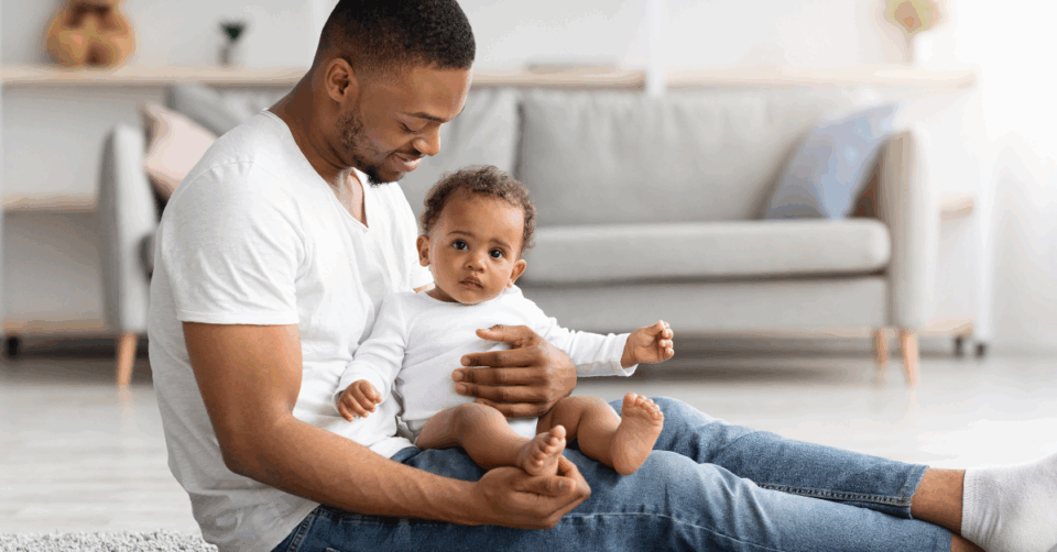 Father sitting on floor with young baby