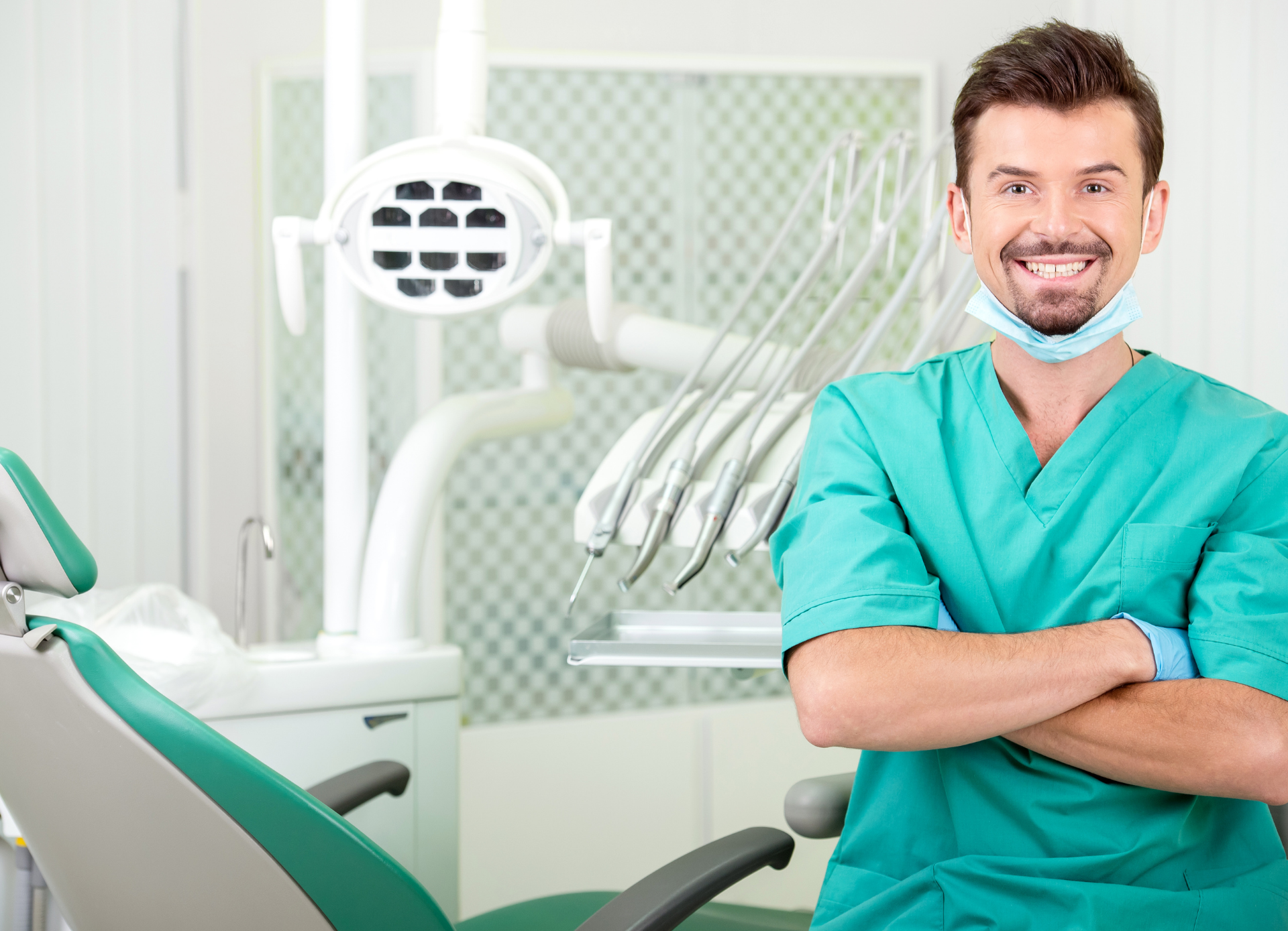 Smiling-young-male-dentist-sat-in-dental-surgery