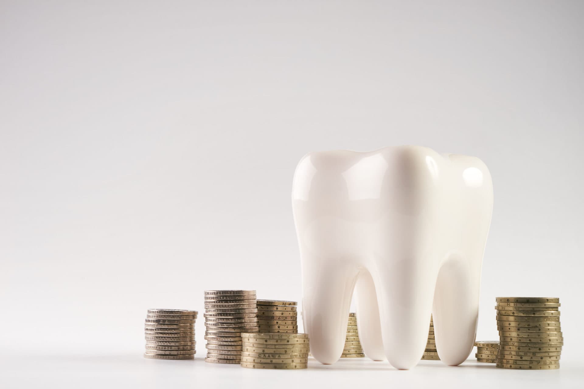 White tooth next to money saved with a dental plan